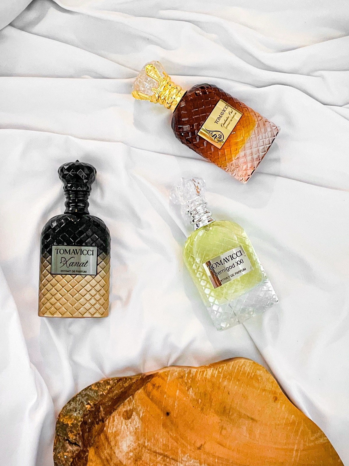 Trei flacoane de parfum pe pânză albă